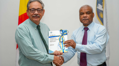 Speaker Mancienne accepting a copy of the Public Enterprises Annual Report 2022 from Mr Zarine