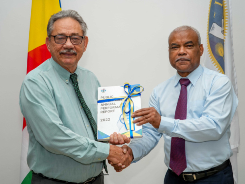 Speaker Mancienne accepting a copy of the Public Enterprises Annual Report 2022 from Mr Zarine