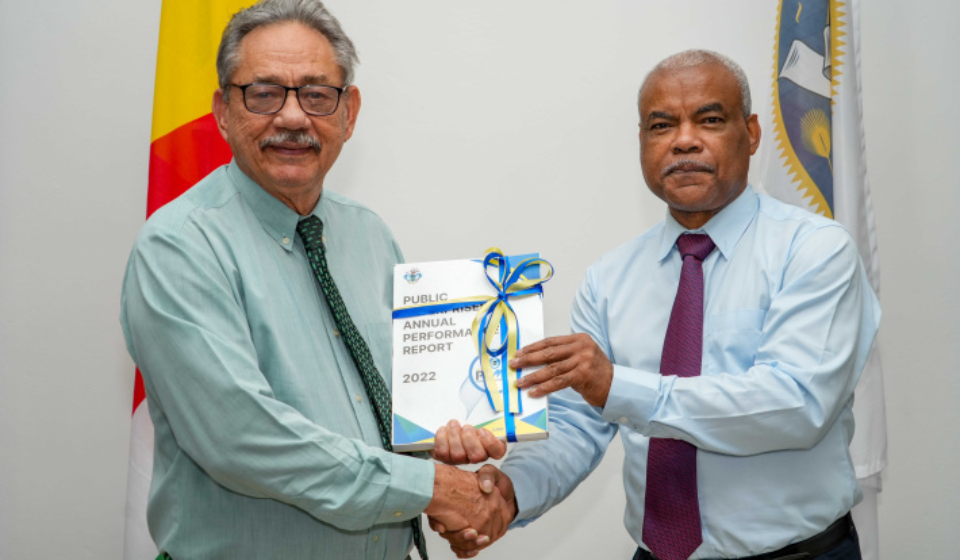 Speaker Mancienne accepting a copy of the Public Enterprises Annual Report 2022 from Mr Zarine